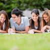 Group of students outdoors studying and looking happy